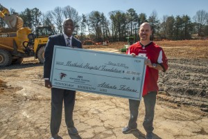 Atlanta Falcons players Matt Bryant and D.J. Shockley present a $30,000 check to Northside Hospital during the East Cobb Medical Center groundbreaking to support the onocology program.