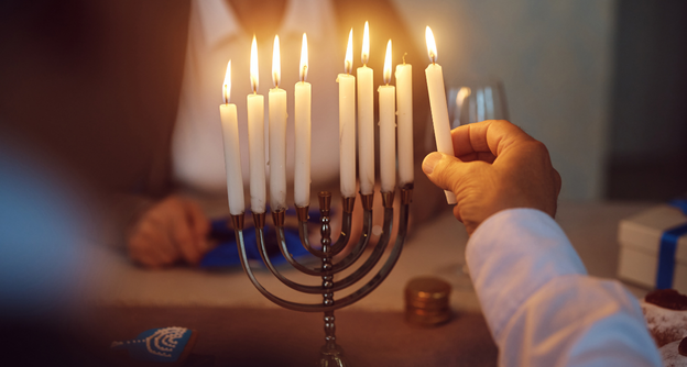 a person lighting a menorah